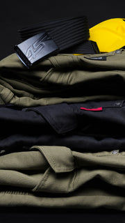 Stack of folded 4SR Tourismo motorcycle jeans in green and black with black 4SR belt and yellow Safe Tech protector on top.