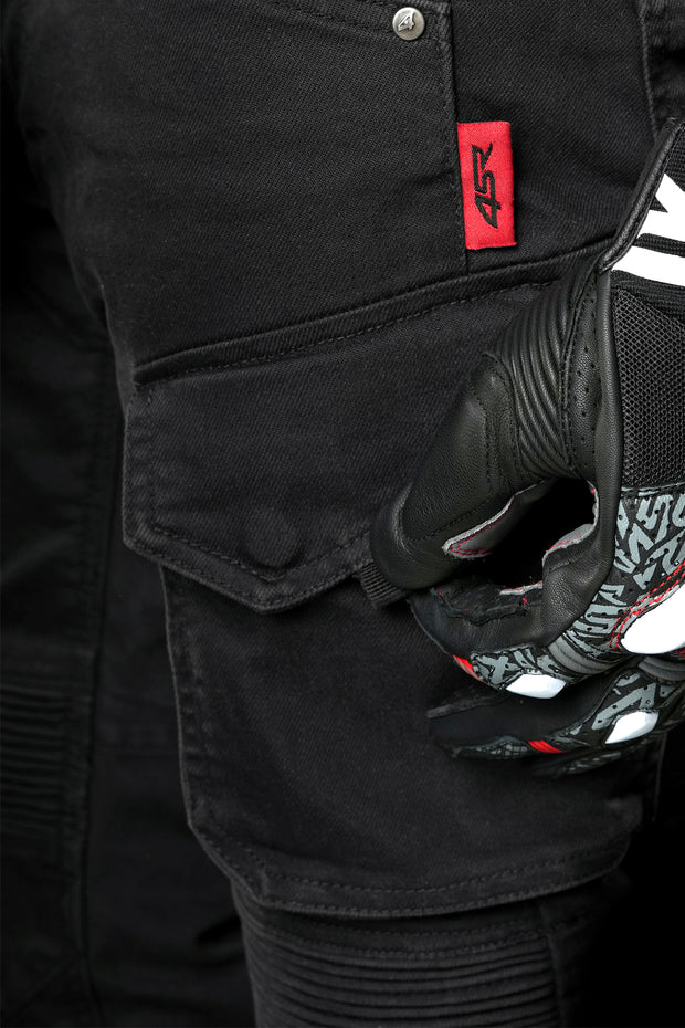 Detail of 4SR Tourismo Black motorcycle jeans cargo pocket with red 4SR label, shown with rider wearing protective glove.