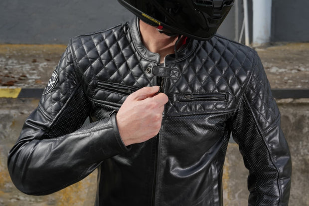 Lifestyle photo – rider adjusting zipper -Motorcyclist wearing 4SR Scrambler Petroleum II leather jacket, adjusting the zipper while wearing a helmet.